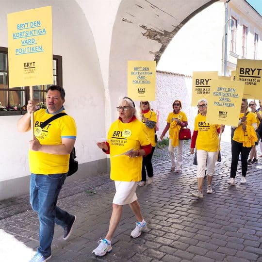 Personer syns gå i ett demonstrationståg med skyltar från kampanjen