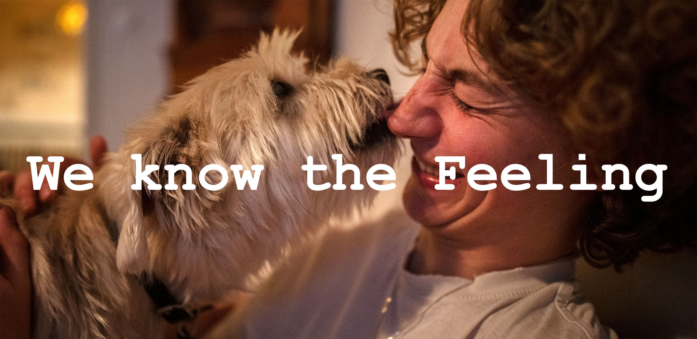 En hund pussar en kvinna i ansiktet och texten we know the feeling